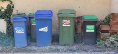 Six conteneurs à déchets de trois couleurs différentes selon le type de déchets, sur un trottoir de Dampierre