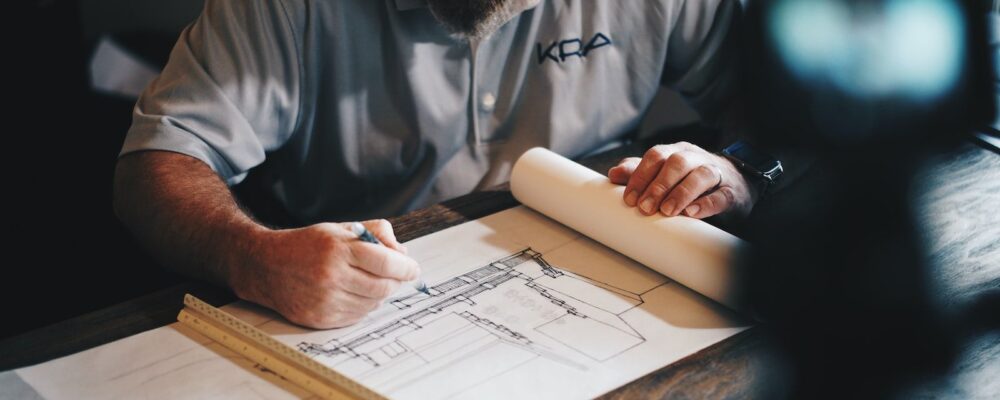 Un architecte dessinant un plan avec crayon et règle